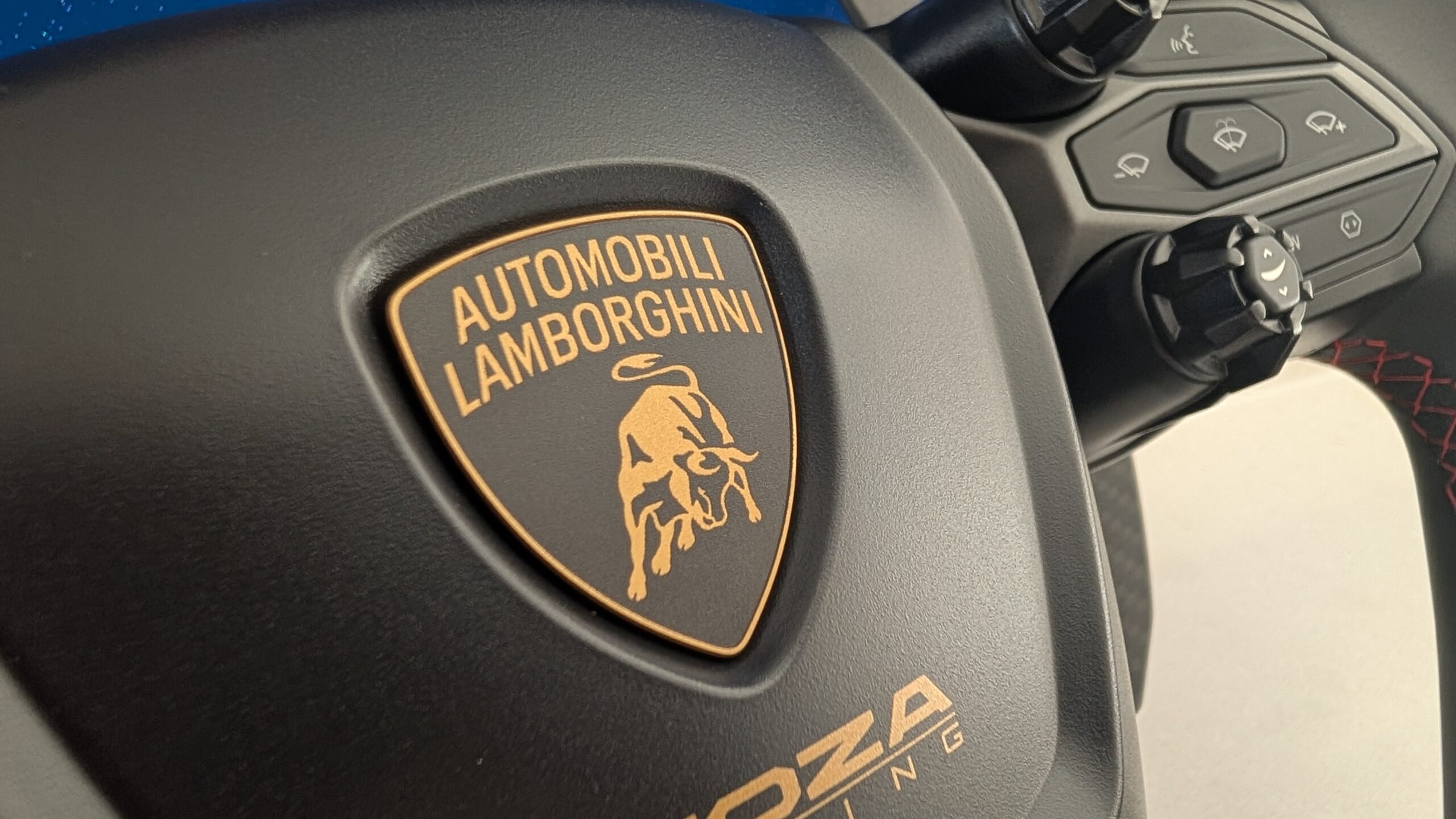 MOZA Lamborghini Revuelto centre badge close-up showing the Automobili Lamborghini crest and MOZA Racing logo