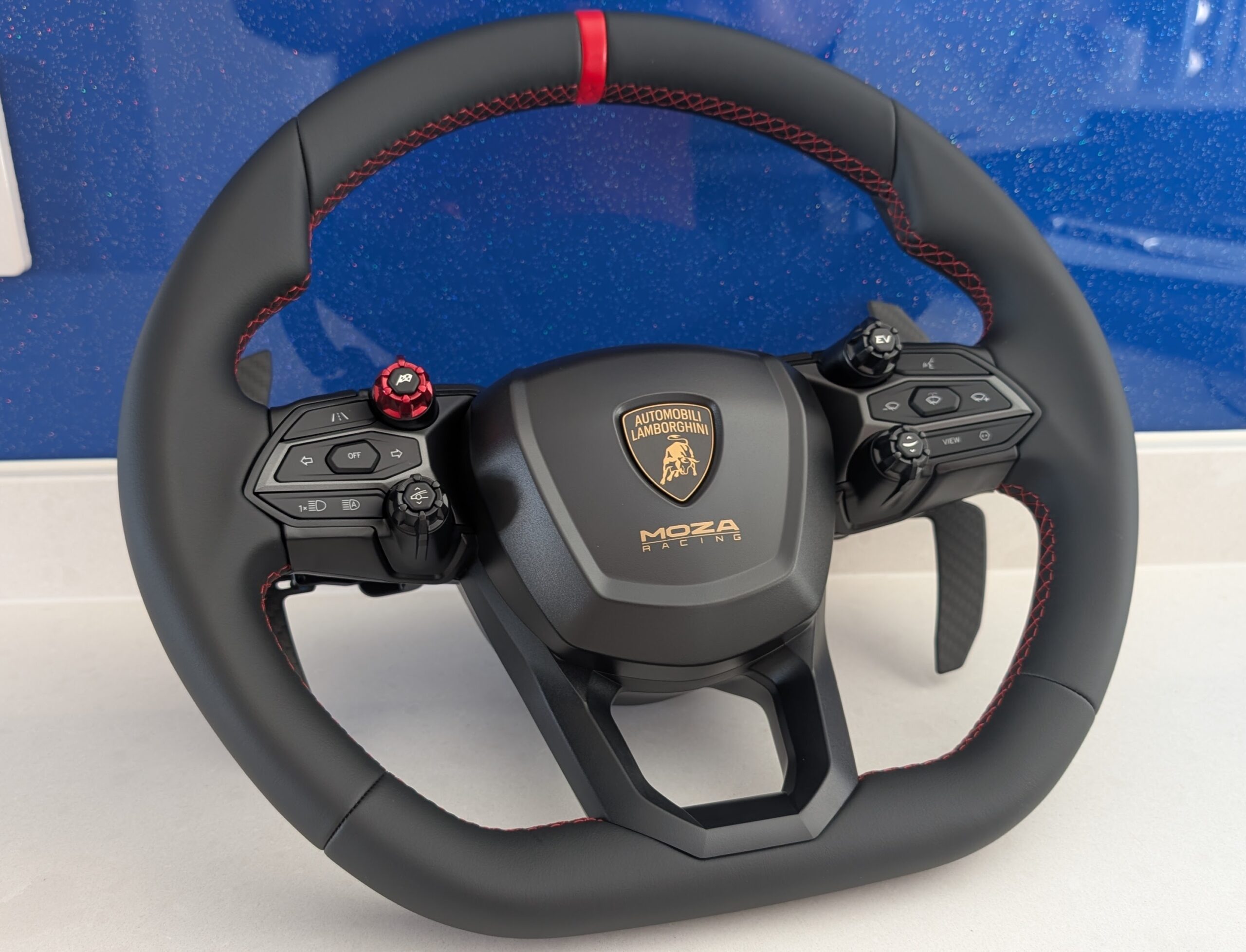 MOZA Lamborghini Revuelto steering wheel front view showing the Lamborghini badge, rotary dials, and backlit buttons
