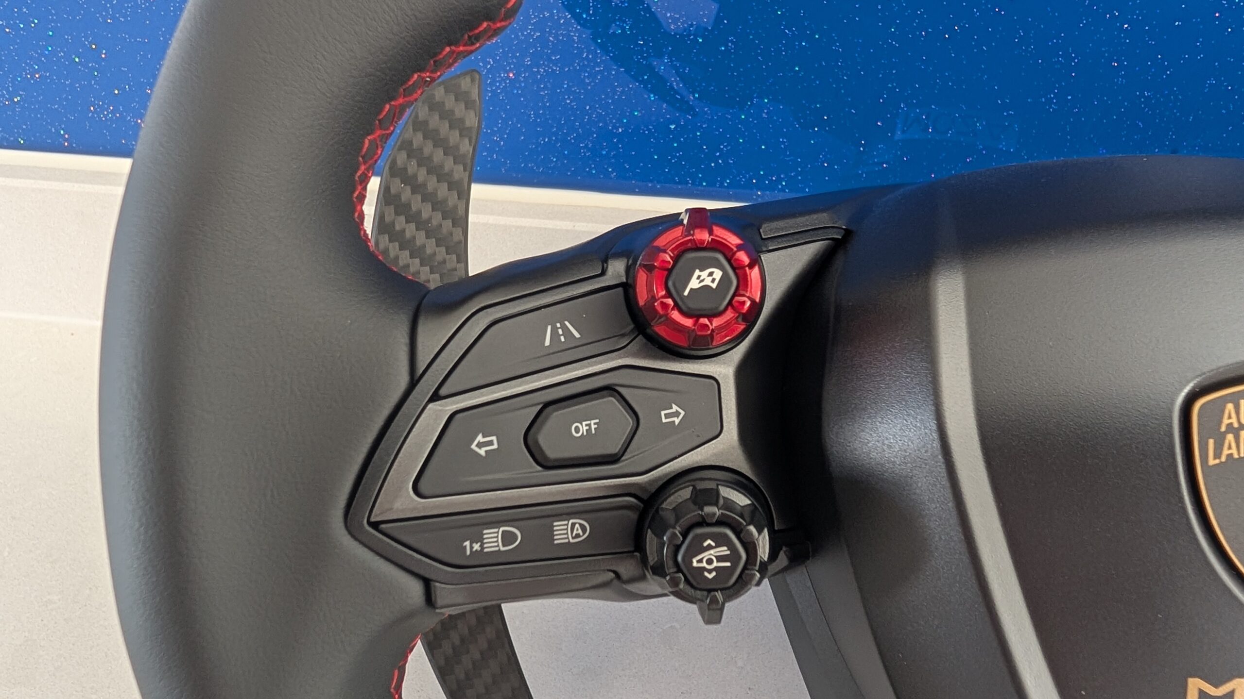 MOZA Lamborghini Revuelto left spoke showing backlit buttons, red rotary dial, and control layout