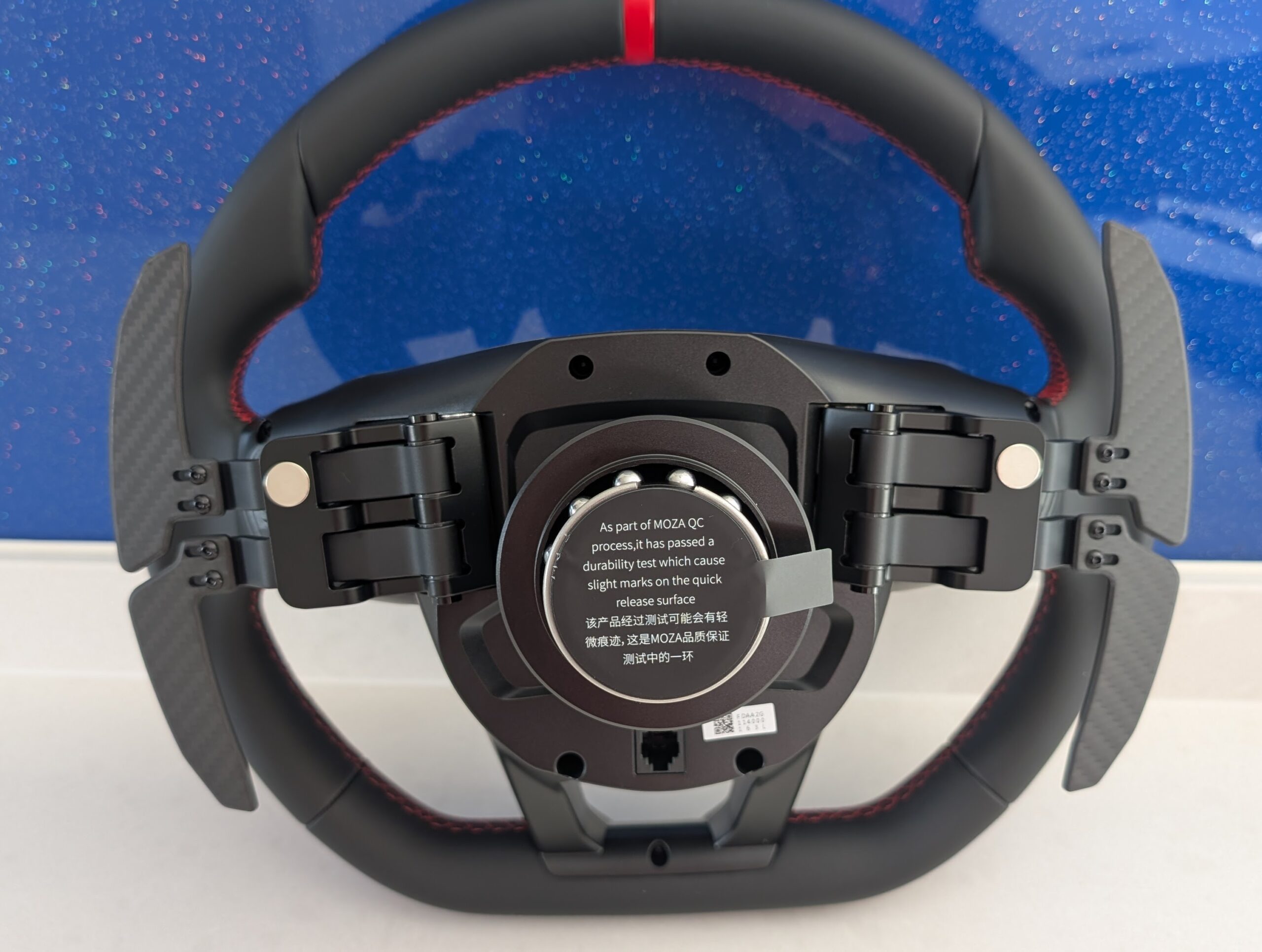 MOZA Lamborghini Revuelto rear view showing carbon fibre shifter paddles, dual clutch paddles, quick release, and rear buttons