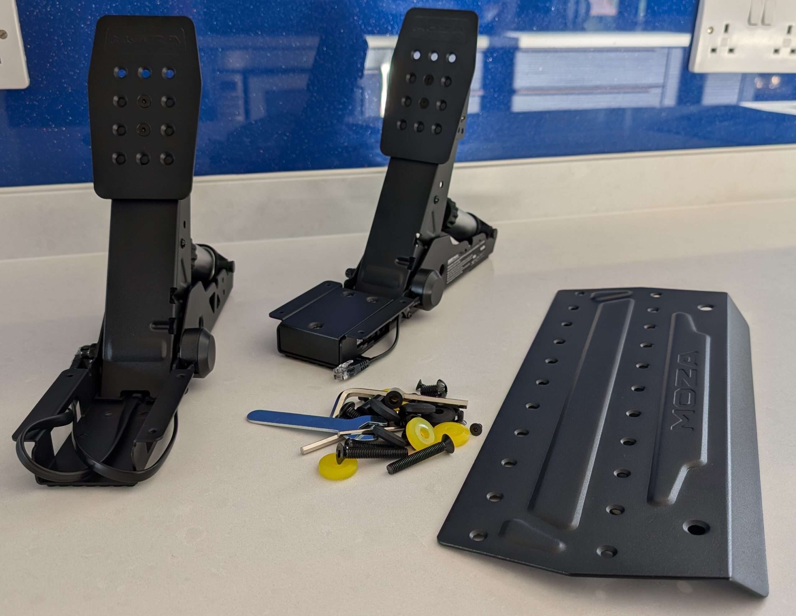 MOZA SRP2 unboxed - both pedals, base plate, and mounting hardware laid out
