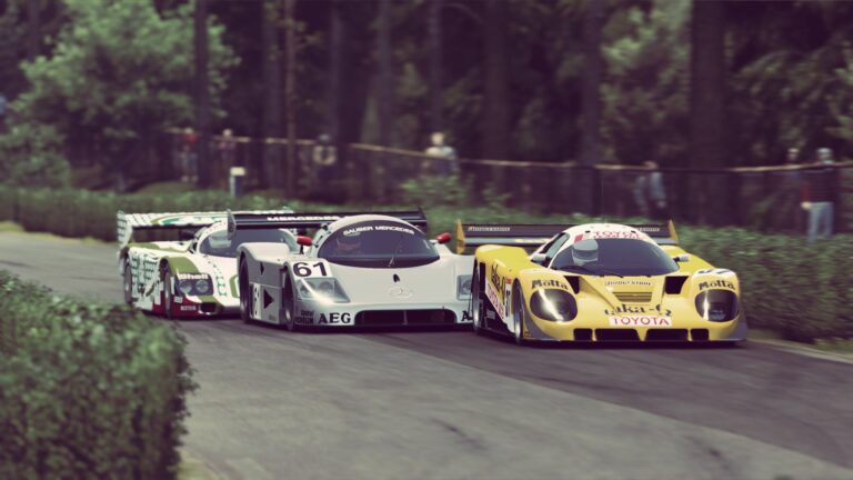 Three Group C prototypes cornering in Automobilista 2 - Mercedes-Sauber AEG, Toyota Eka/Motta, plus third car - tree-lined corner