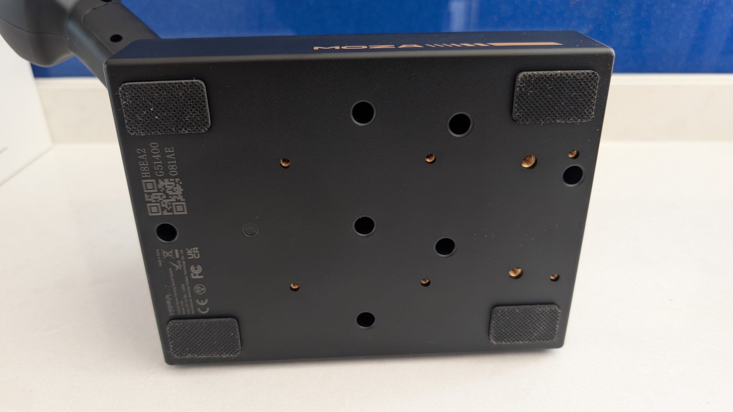 MOZA FCS base underside showing rubber feet and threaded mounting holes