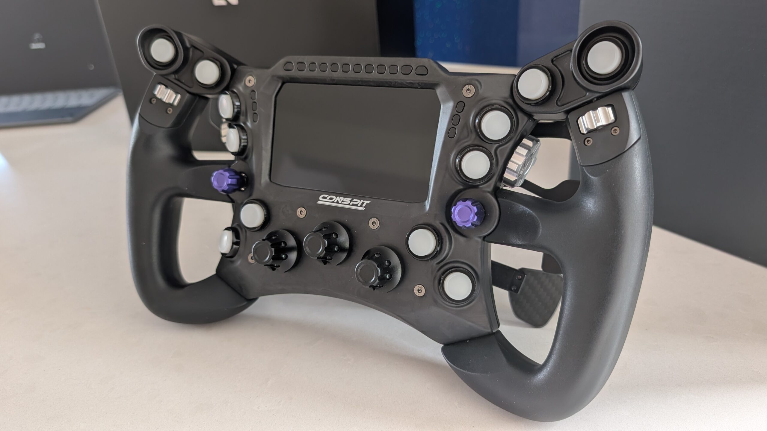 Conspit 290 GP formula wheel, front three-quarter view, display off