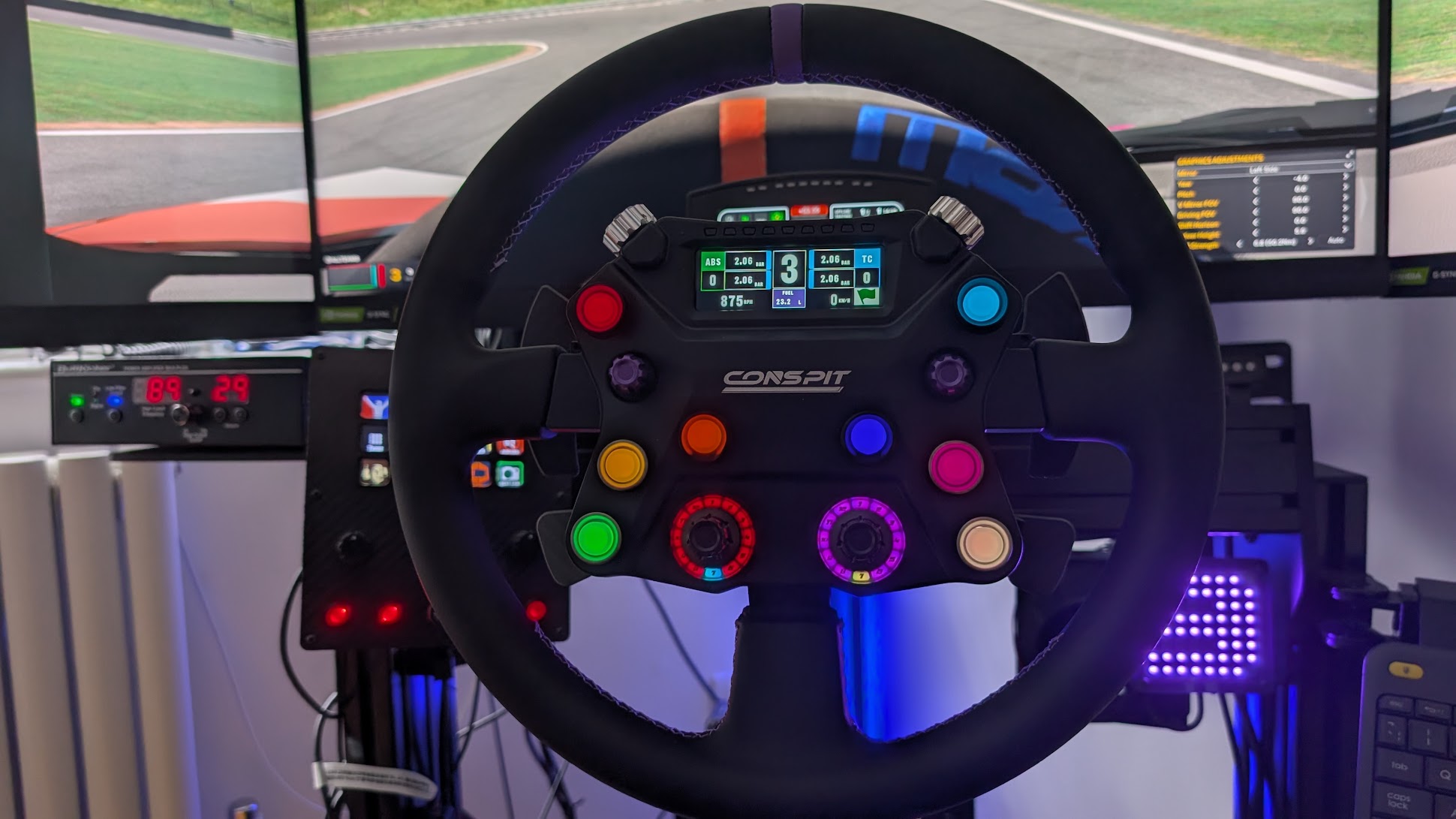 Conspit 310 APEX steering wheel mounted on a Simucube 2 Pro, buttons lit, Lime Rock Park on triple screens behind