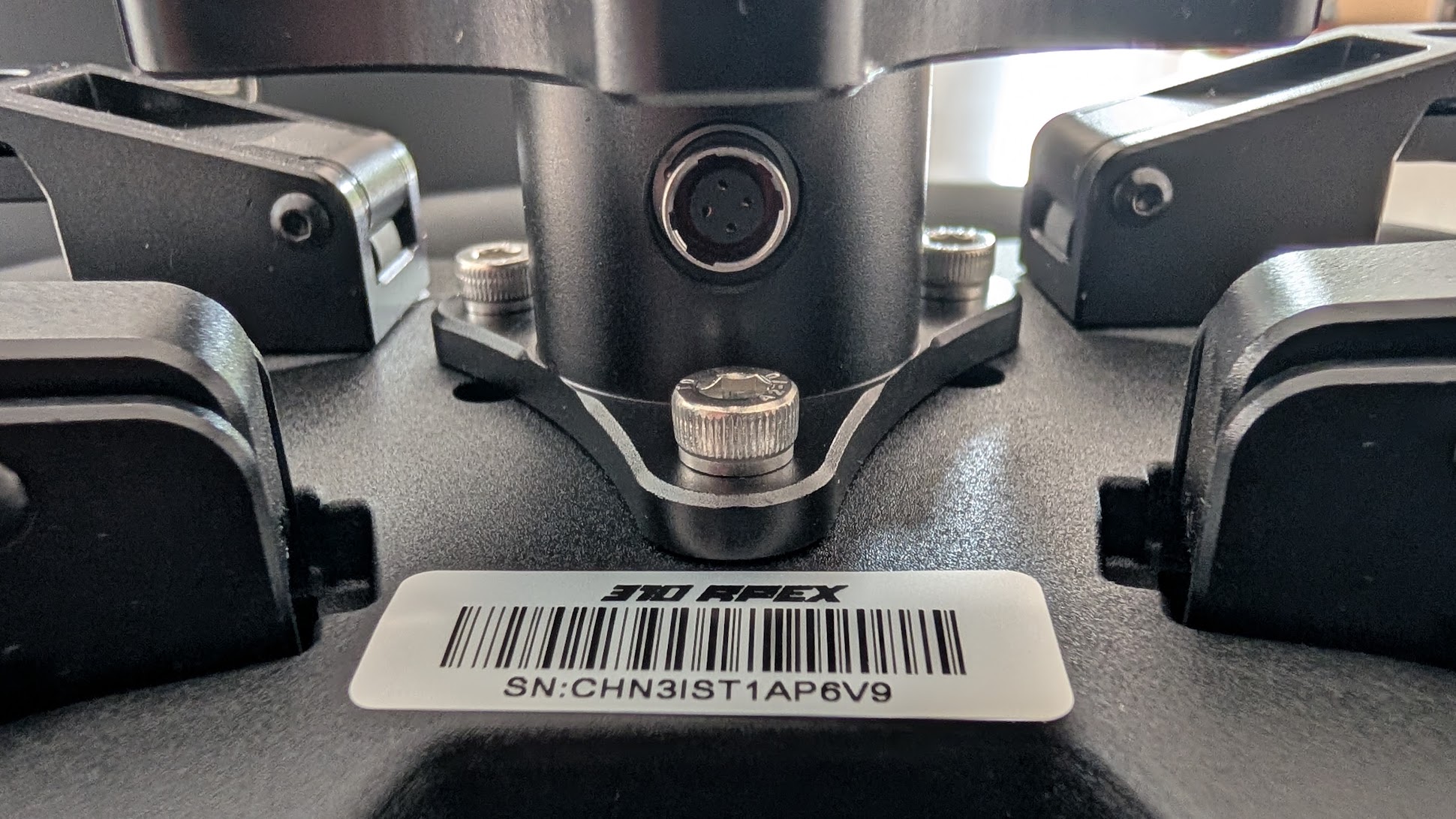 The 4-pin connector at the centre of the Conspit 310 APEX hub, with the serial label below