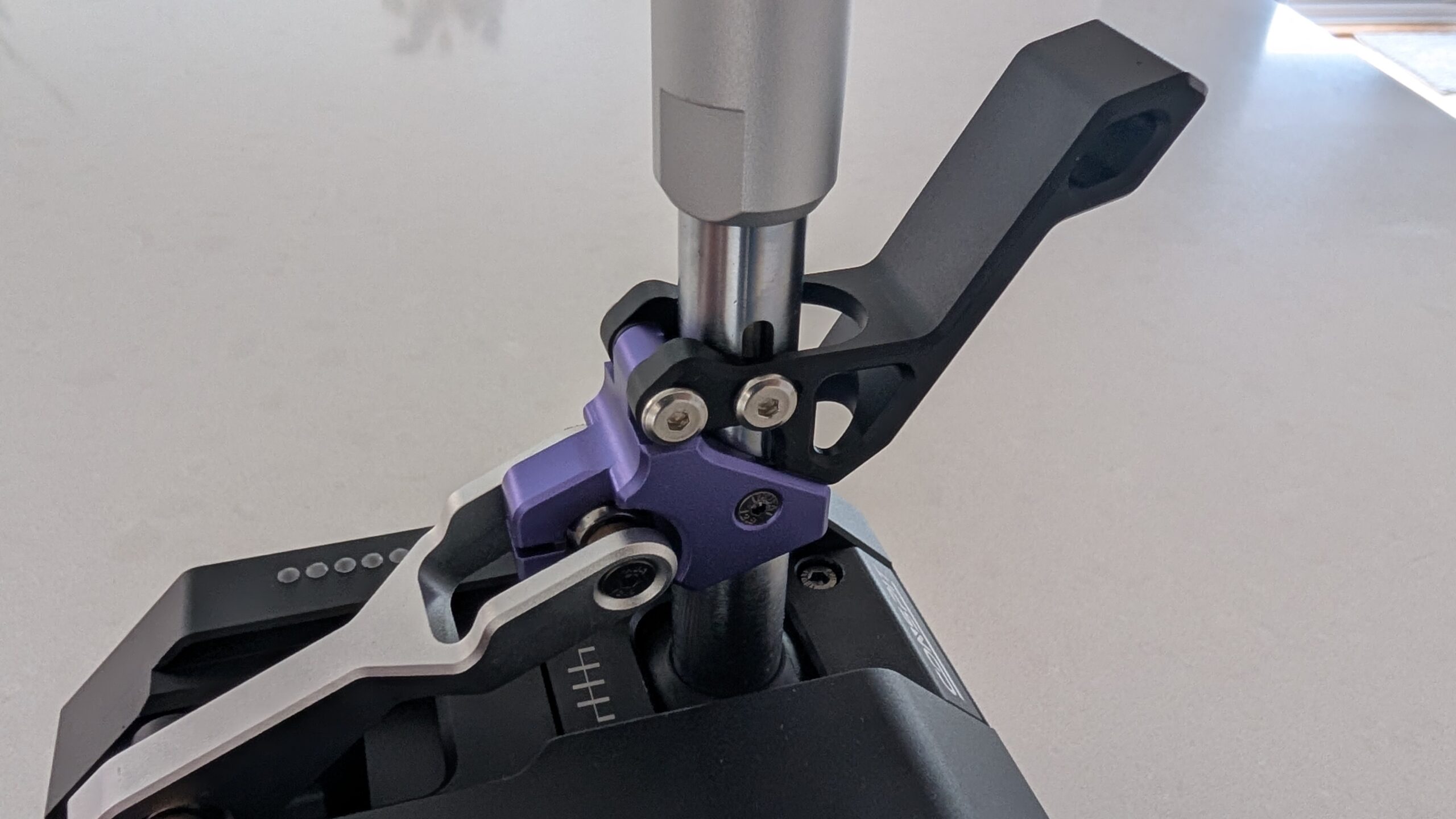 The black reverse lockout trigger on the purple collar of the CONSPIT CHS, close up