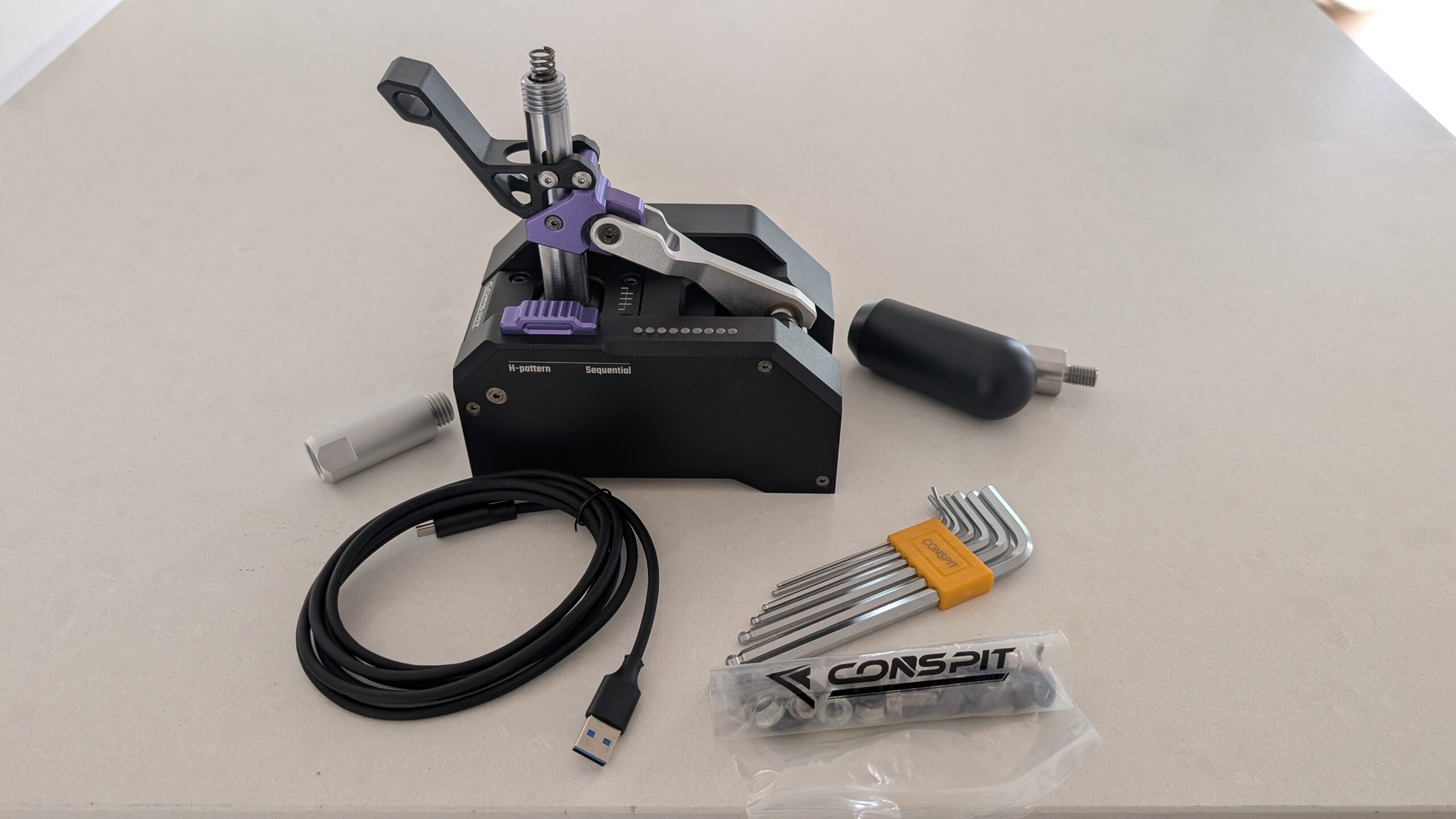 CONSPIT CHS contents laid out: shifter, knob, shaft extension, USB cable, Allen keys and bolt bag
