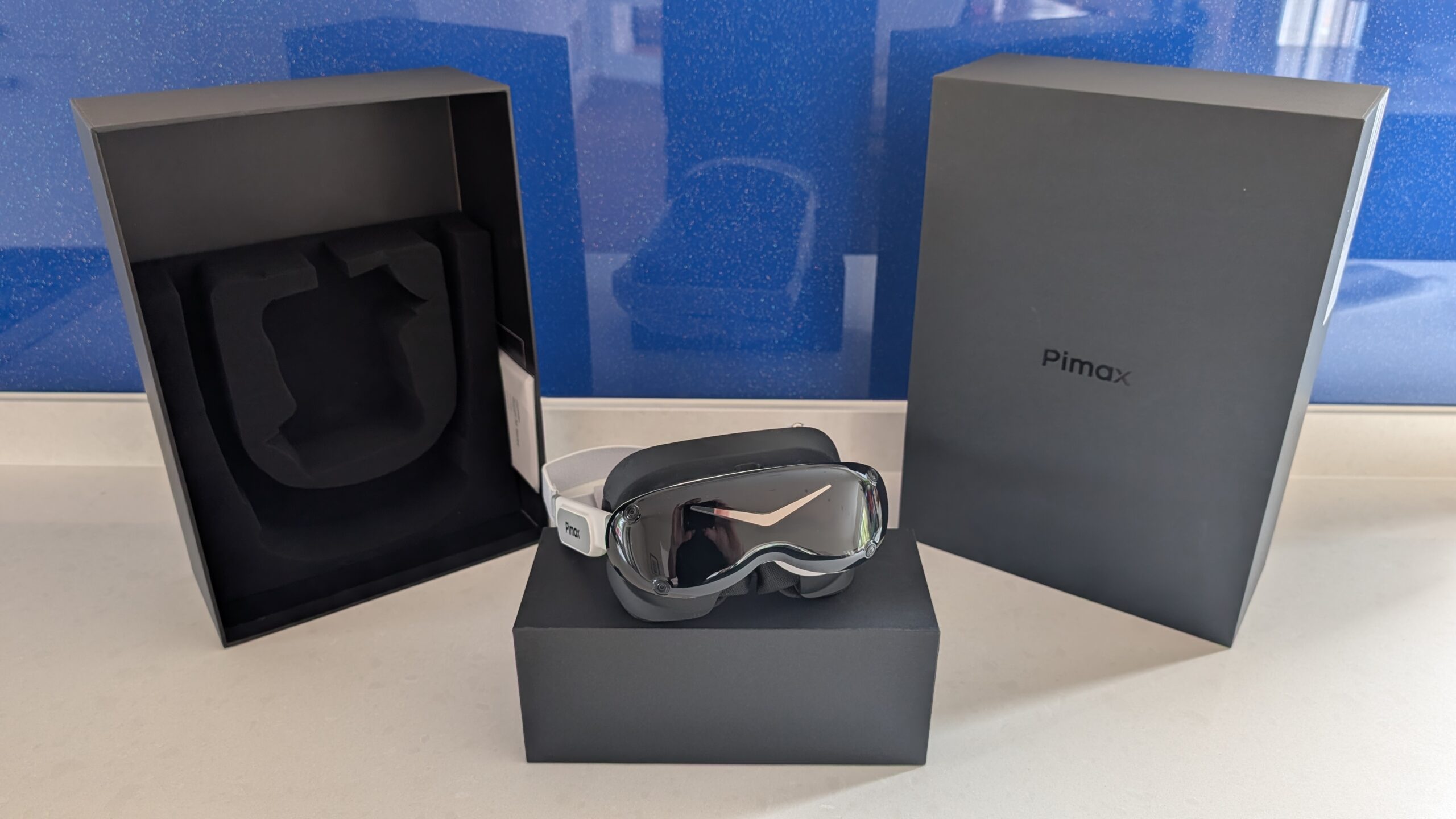 Pimax Dream Air headset resting on its box with the retail packaging behind