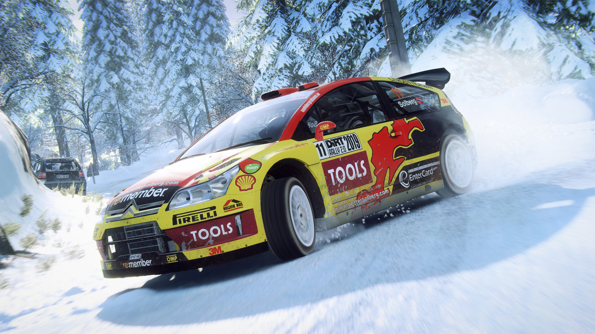 Yellow and red Citroen C4 WRC rally car on a snow stage between pine trees in DiRT Rally 2.0