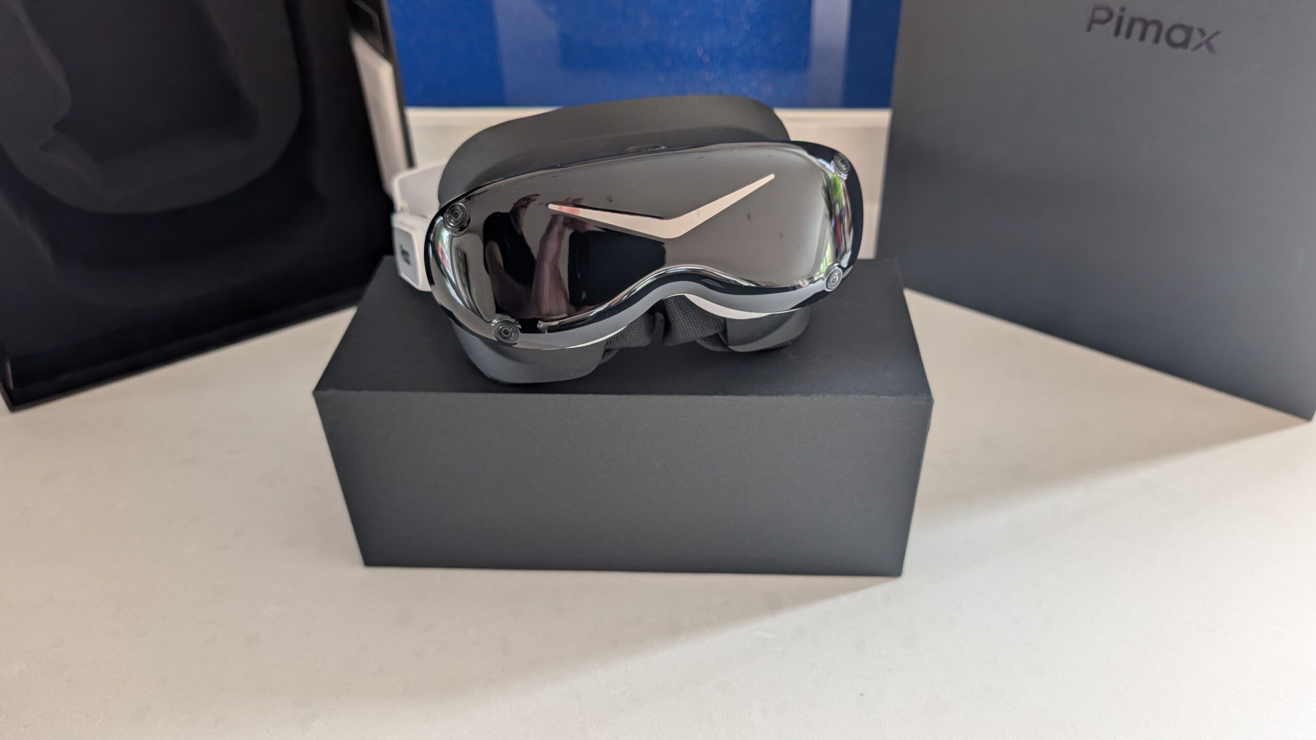Front-on view of the Pimax Dream Air SE, mirrored visor and white strap, sitting on the Pimax box