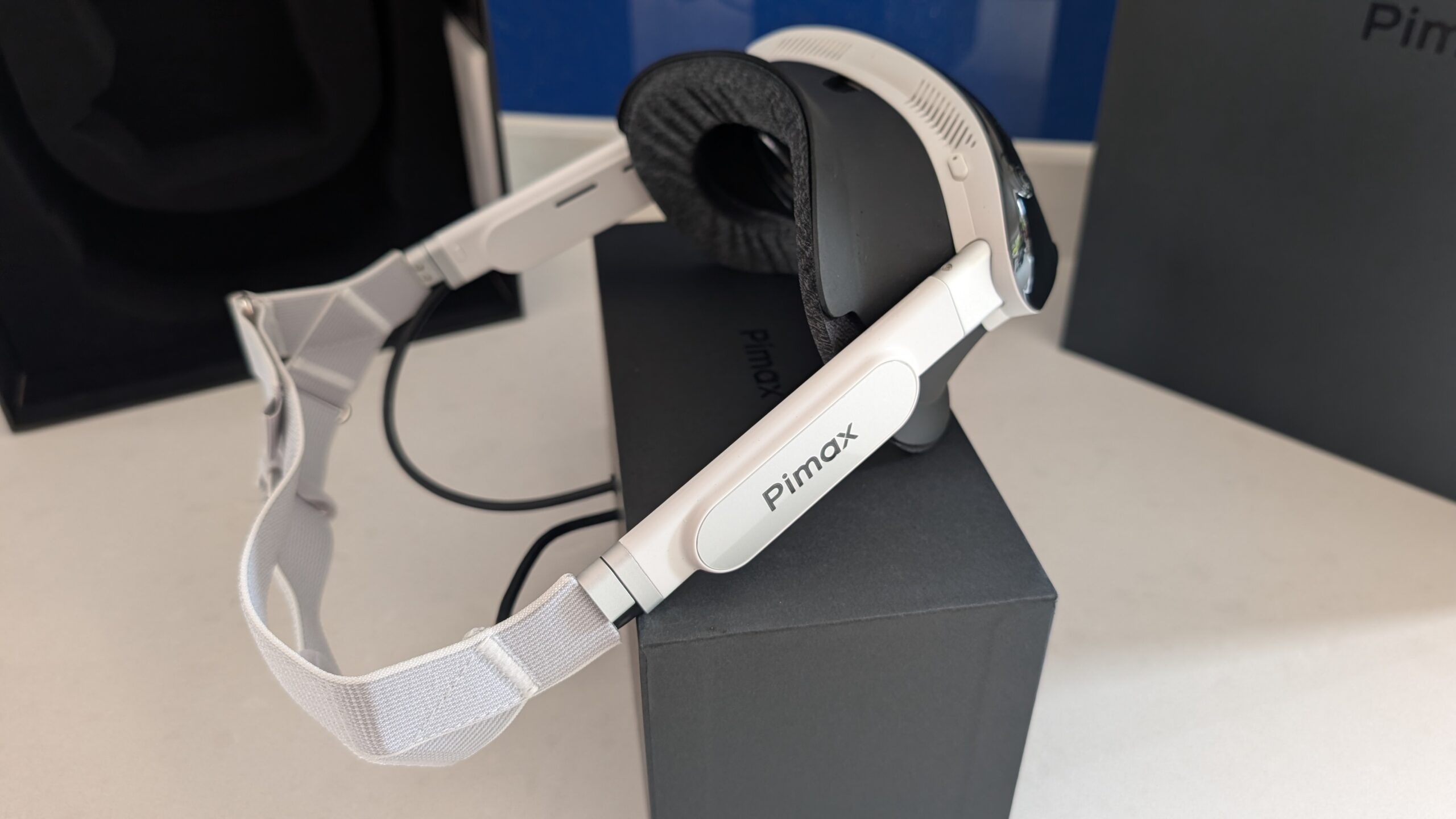 Side profile of the Dream Air SE showing the white strap, the Pimax side arm, the fabric facial interface and the top vents