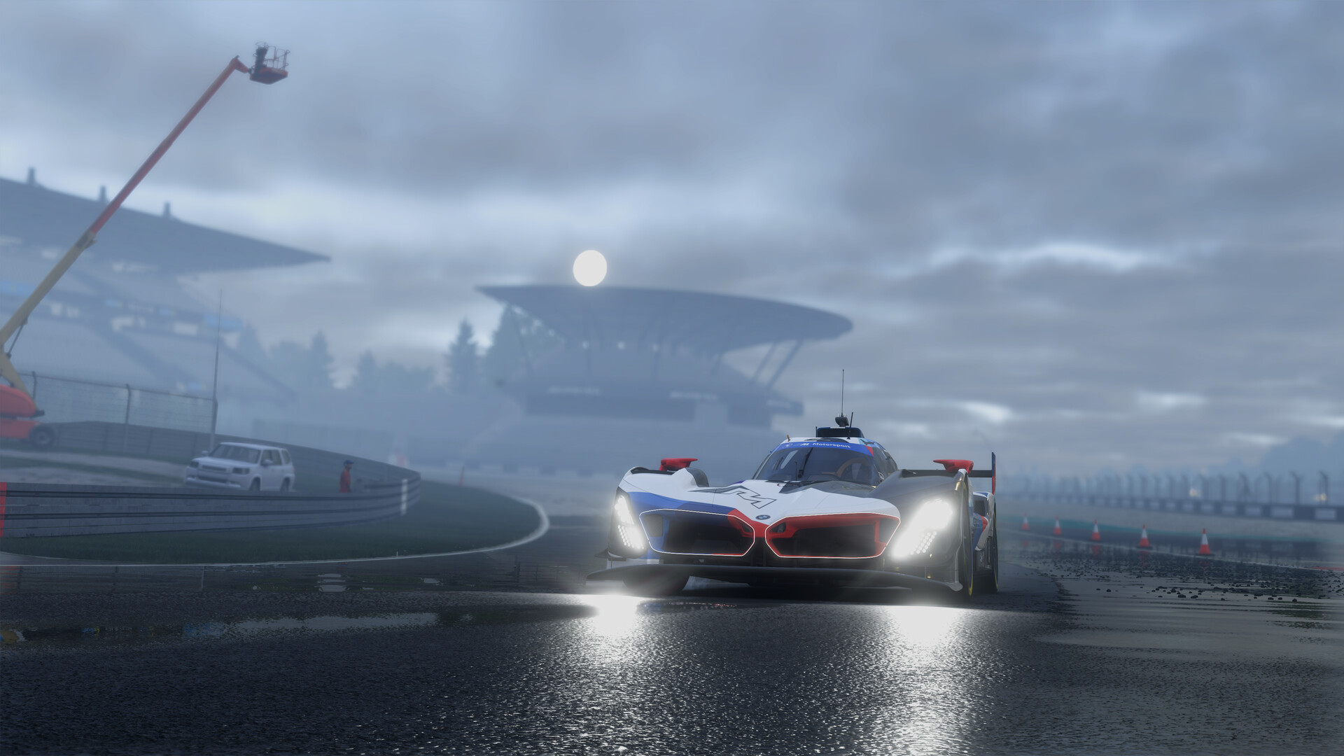A BMW LMDh prototype with headlights on, on a misty wet track in Project Motor Racing