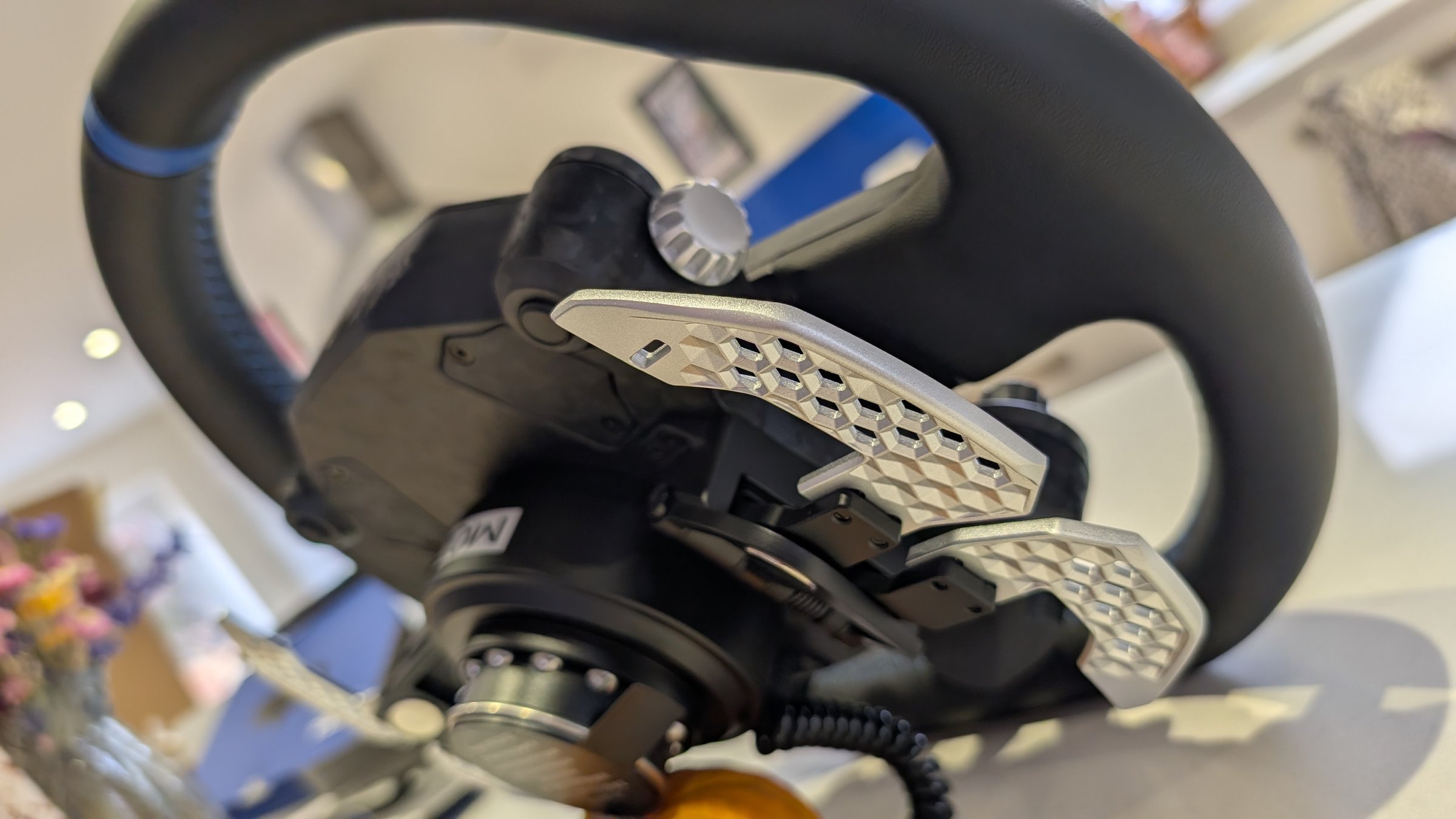 Rear of the MOZA Mustang GTD wheel showing the silver hex-patterned paddles and the quick release hub